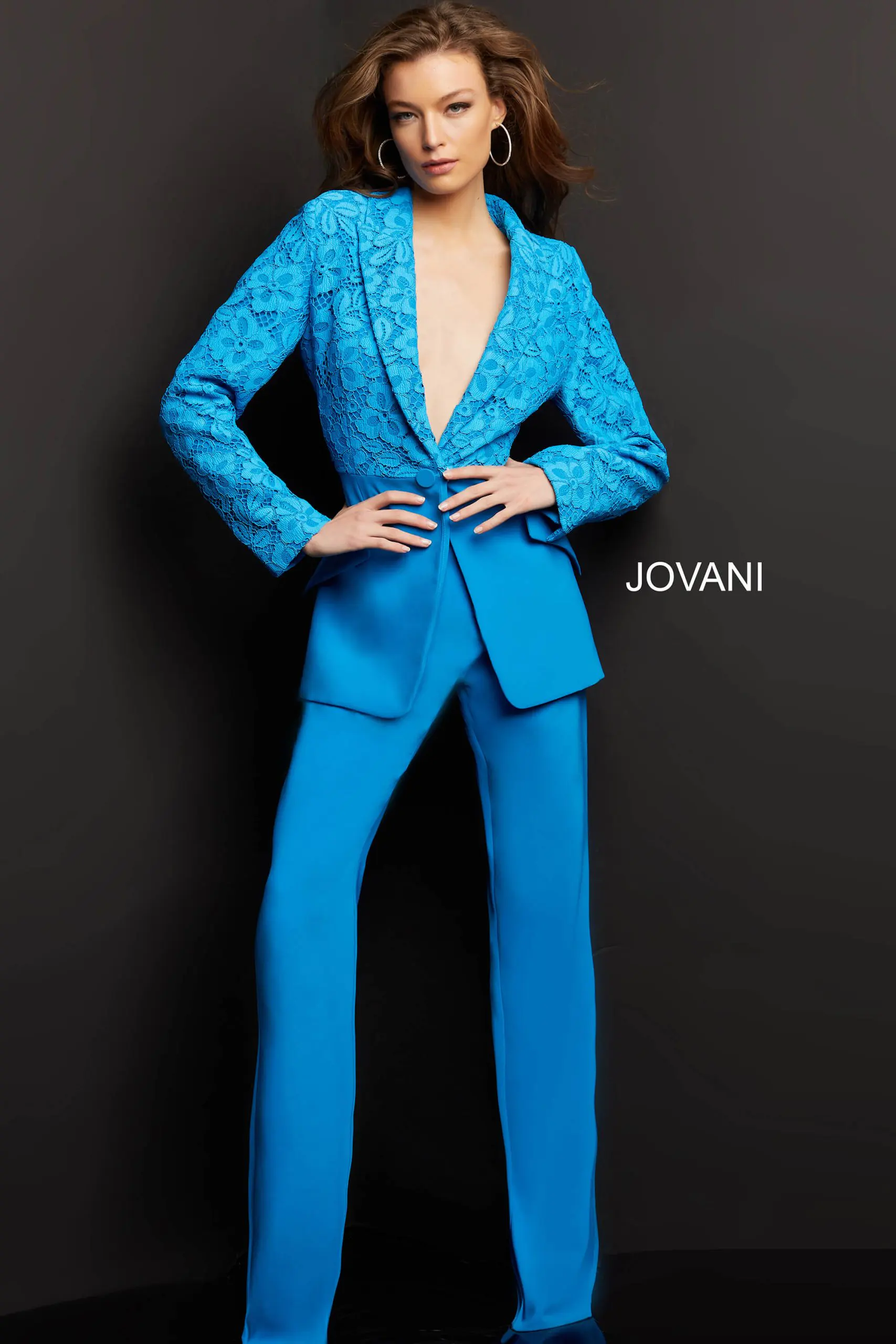 Model wearing Jovani 07551 blue lace blazer with trousers, front view