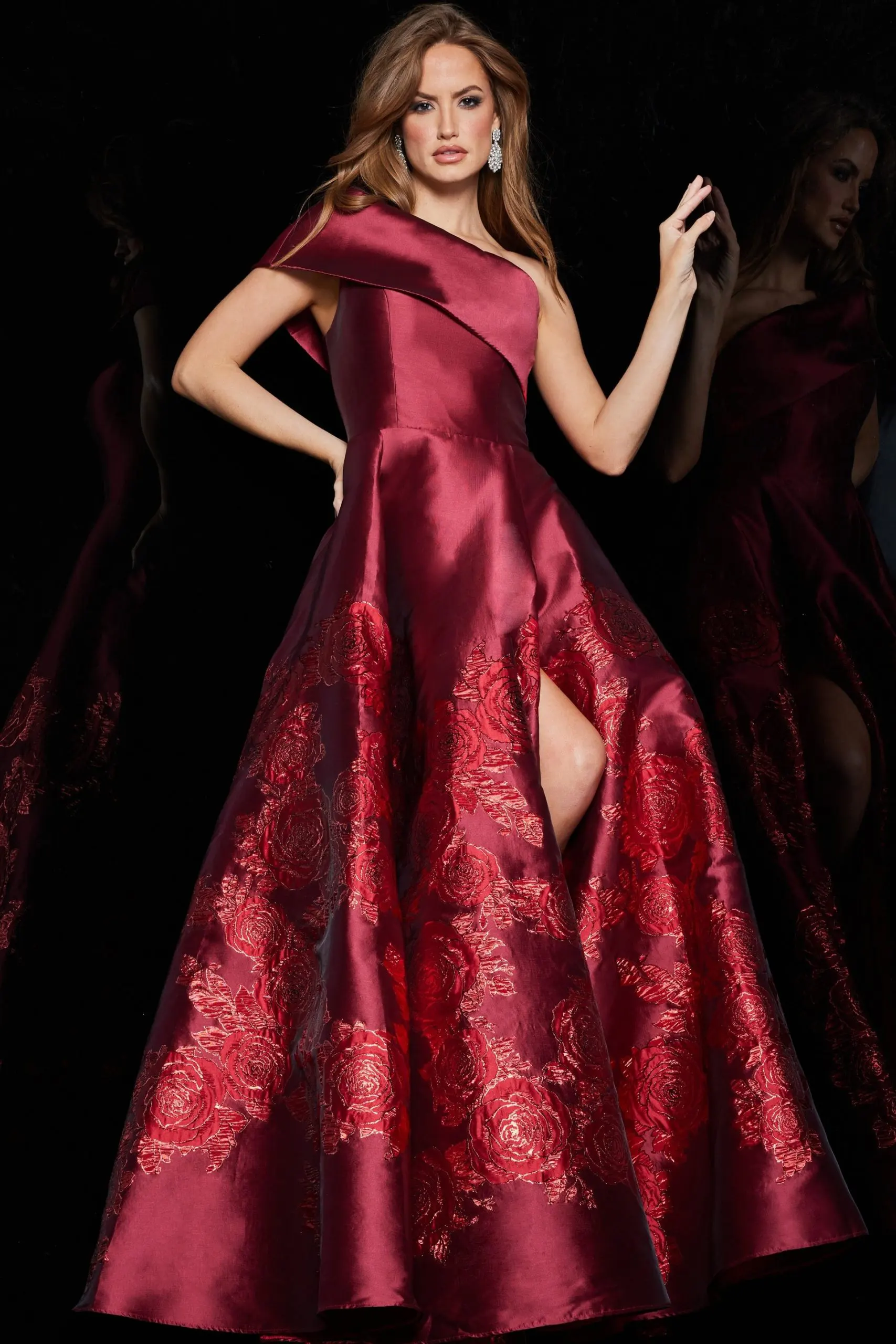 Model wearing Jovani 09610 red dress with asymmetric neckline and floral embroidery.