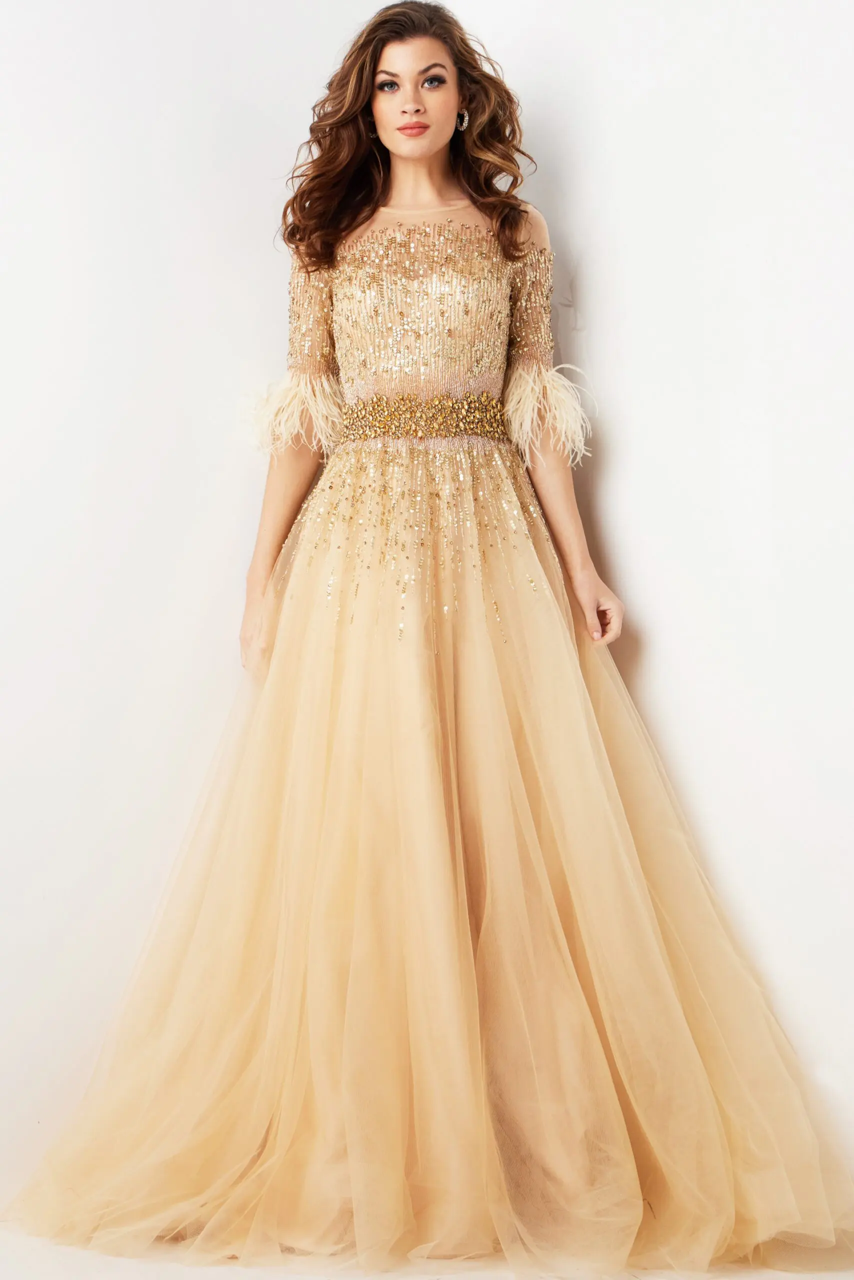 Model wearing Jovani 23629 elegant beige gown with sequined bodice and feathered sleeve details.