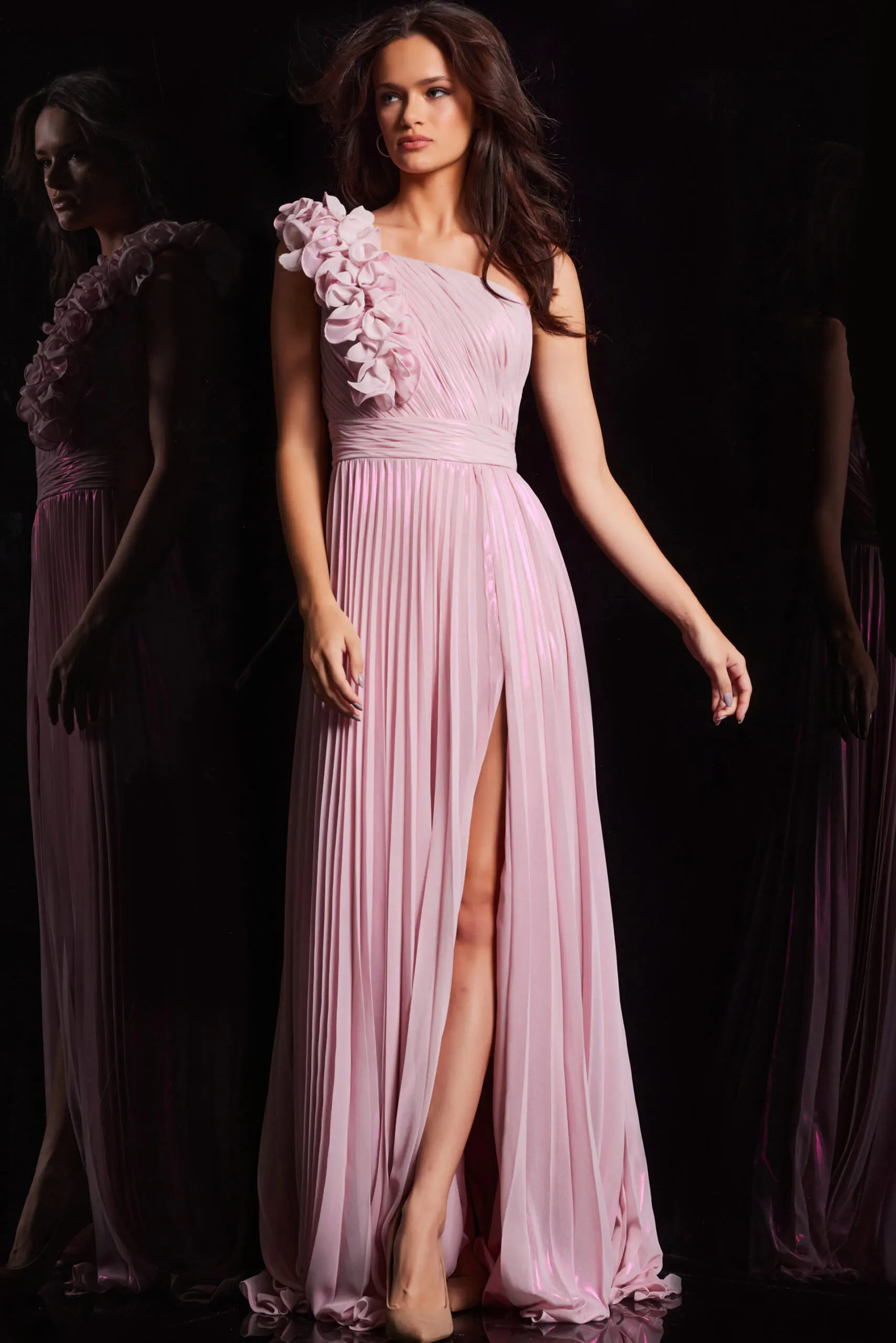 Model wearing Jovani 24609 pink dress with pleated skirt and floral shoulder embellishments.