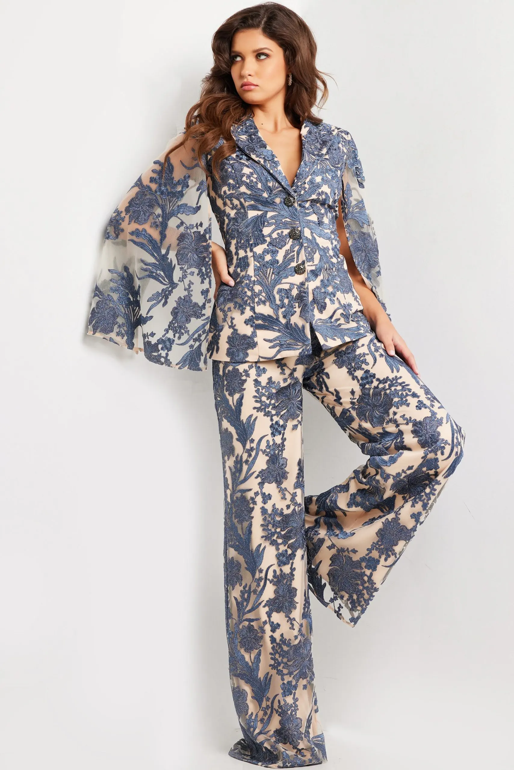Model wearing 25805 elegant navy dress with lace embroidery, side view.