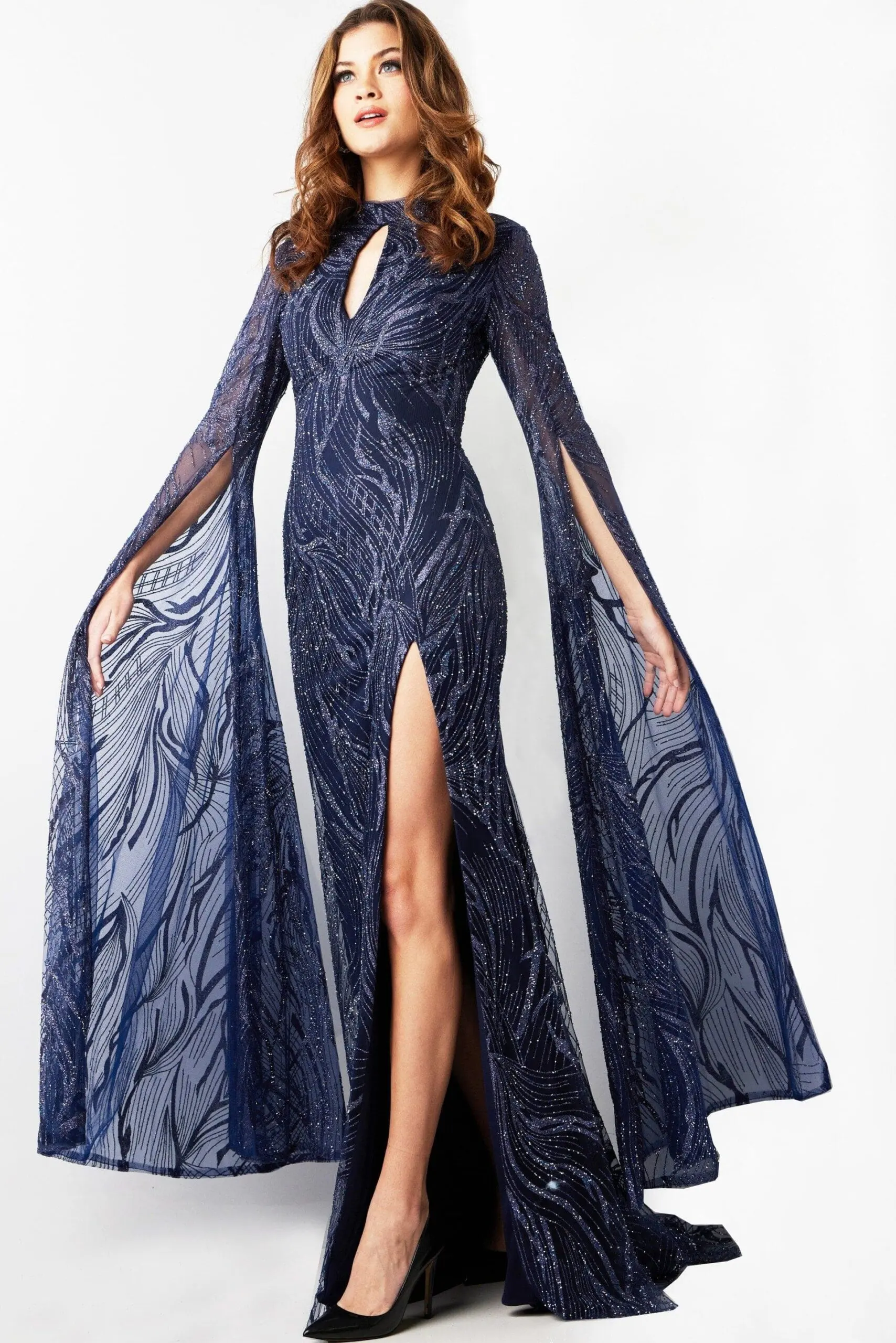 Model wearing Jovani 26092, a navy gown with high neckline and sheer long sleeves.