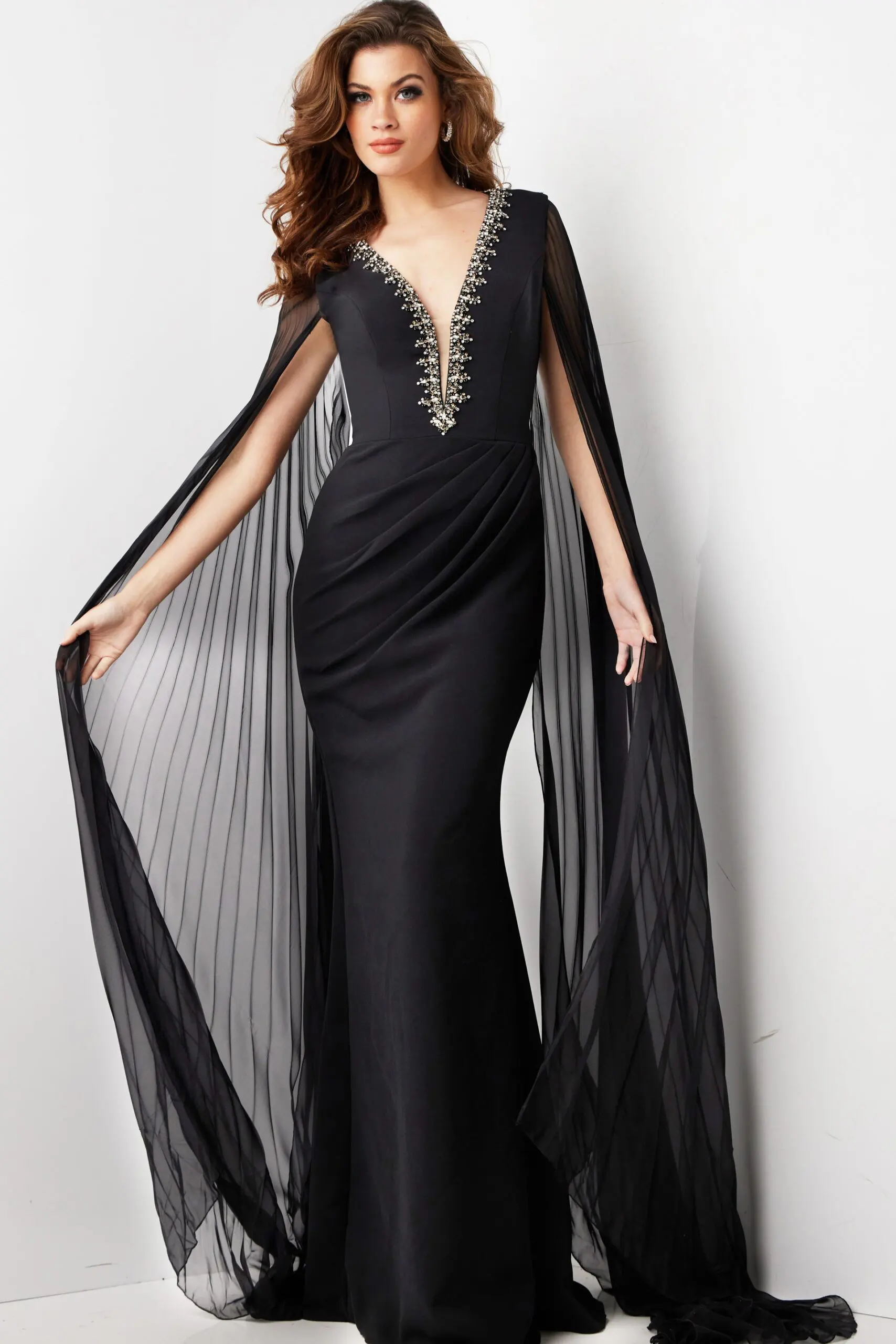 model wearing Jovani 36473 elegant black gown with deep V-neckline and draped sleeves