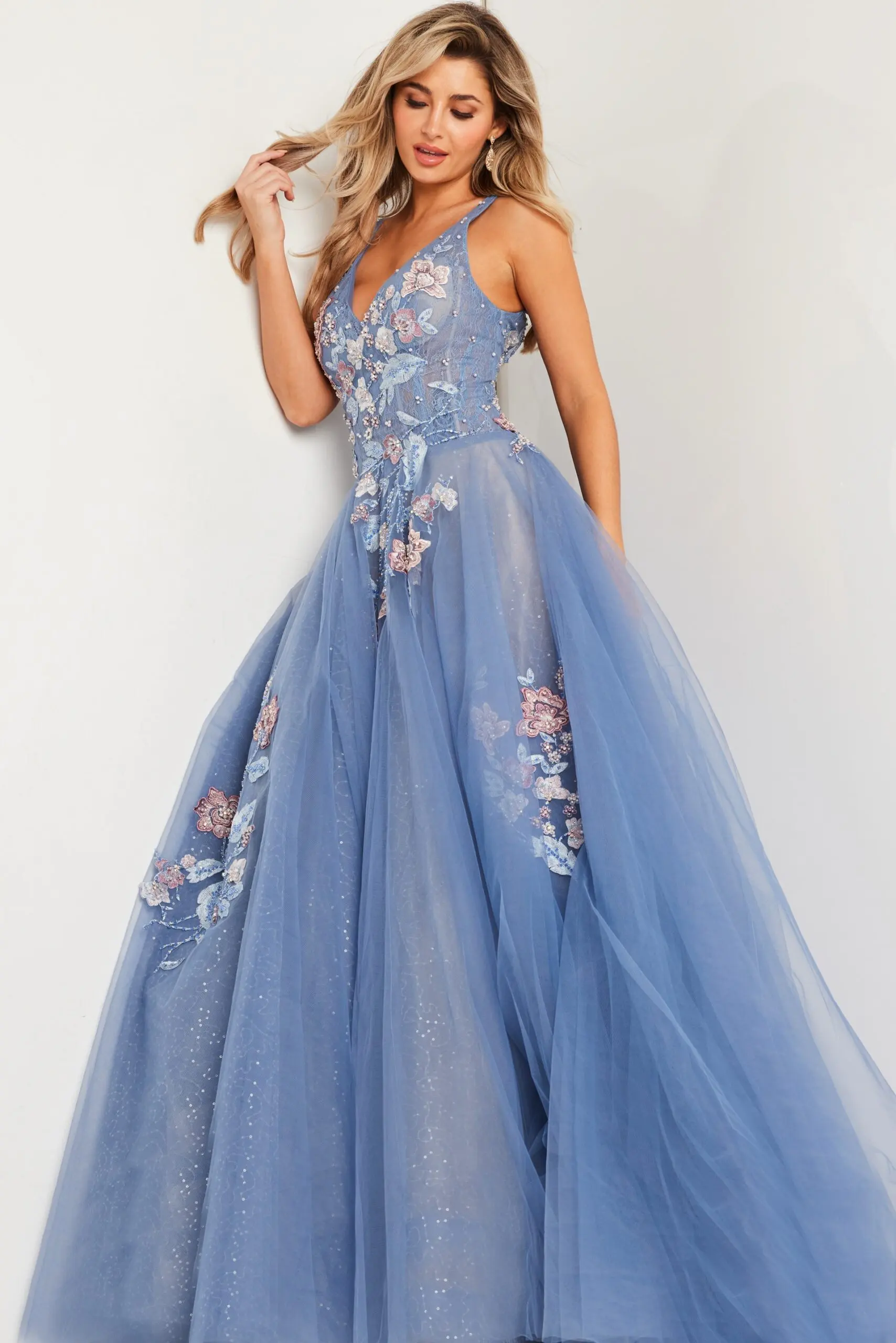Model wearing Jovani 37468 blue gown with floral appliqués from the front.