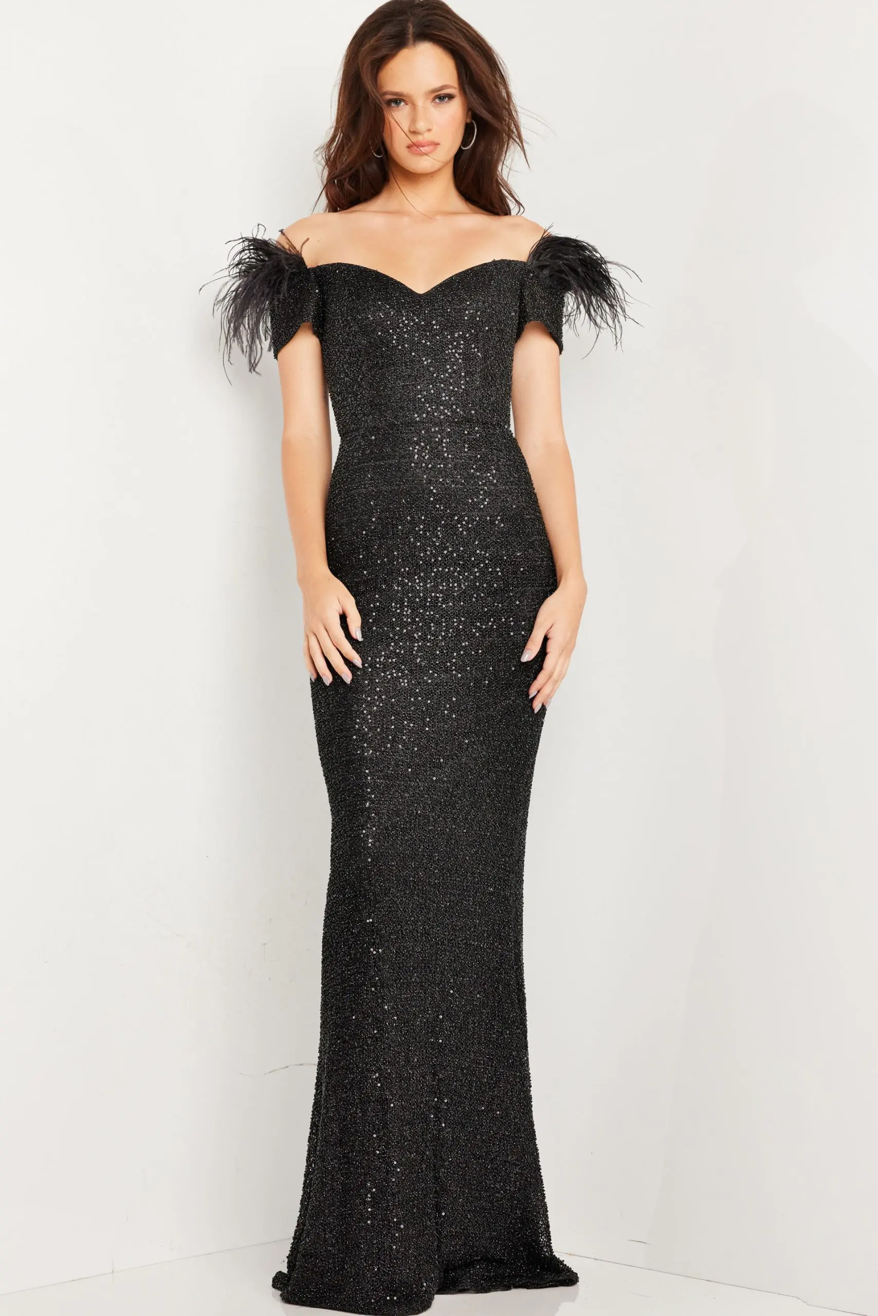 Model wearing Jovani 37562 black gown with off-the-shoulder neckline and feather accents, front view.