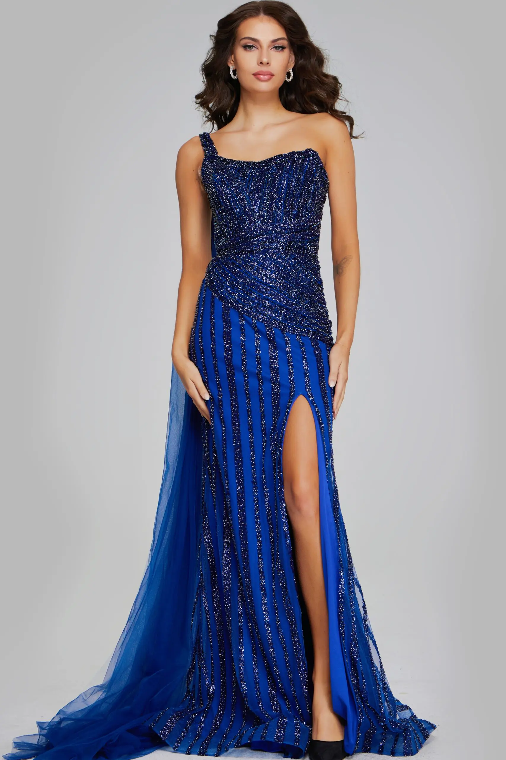 model wearing Jovani 39386 navy gown with beaded design and one-shoulder neckline