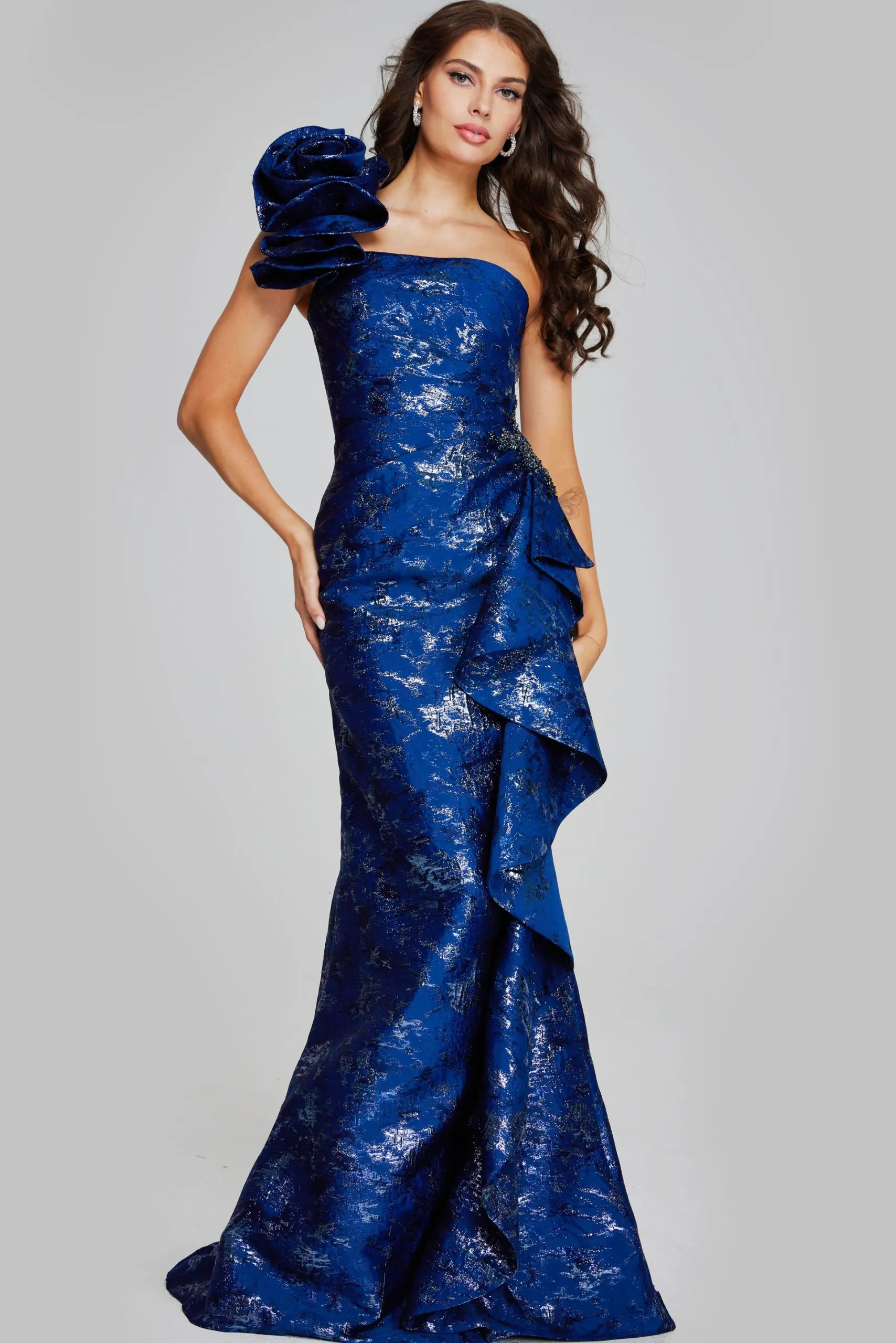 Model wearing Jovani 39438 navy dress with one-shoulder floral detail and mermaid silhouette.