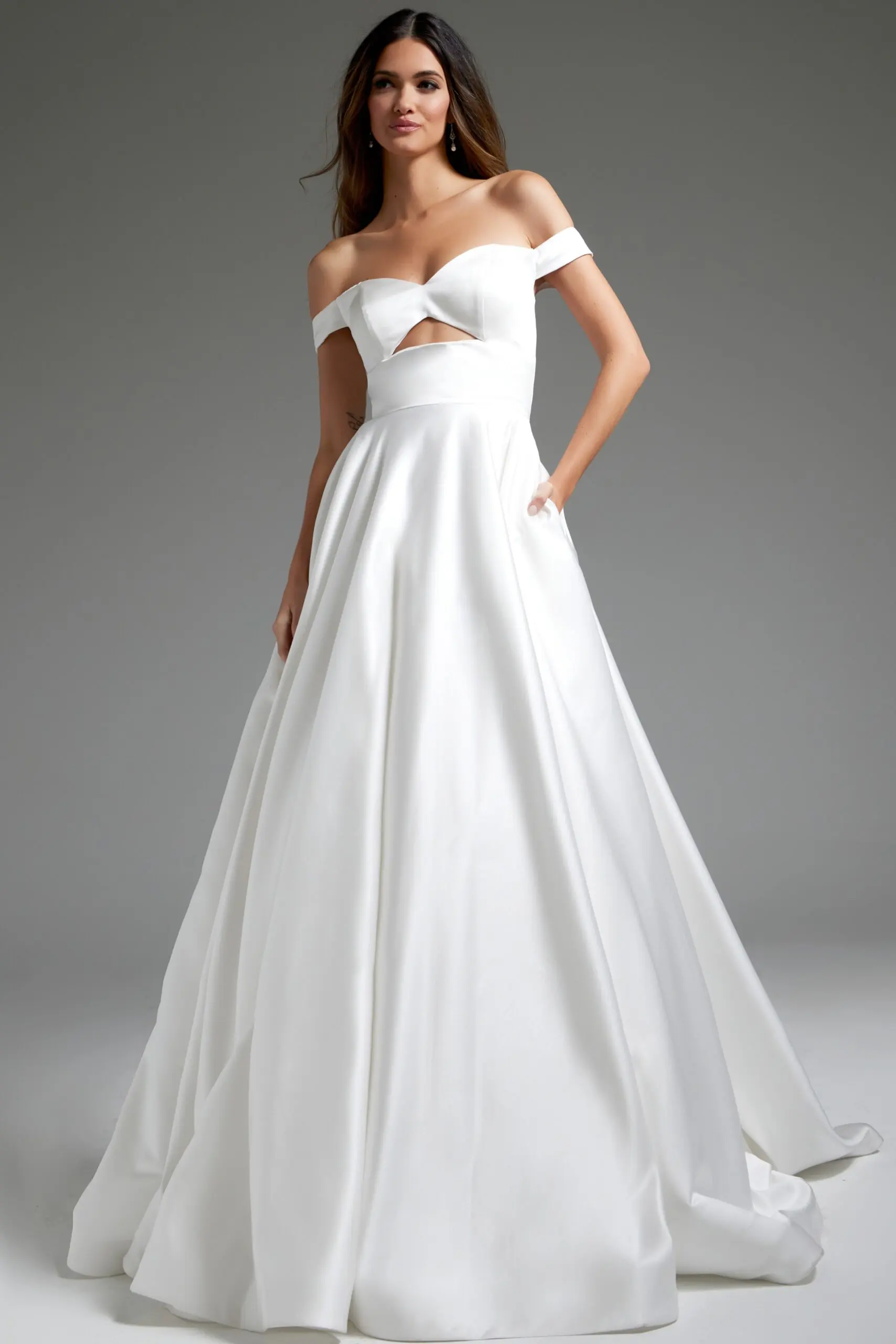 Model wearing Jovani JB42626 off-the-shoulder white dress with cutout at the bodice.
