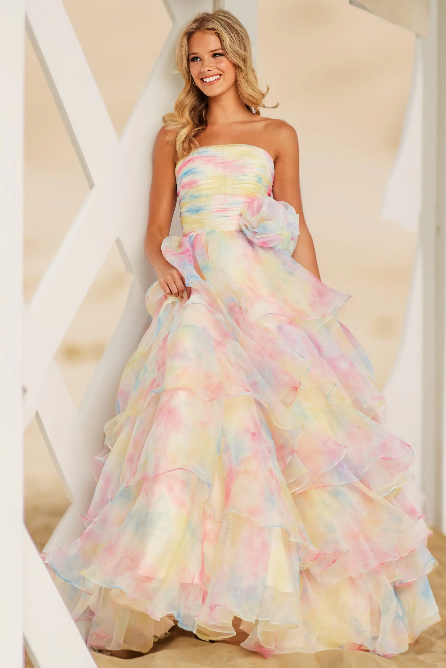 Model wearing Jovani 37456 ivory gown with ruffles and strapless neckline.