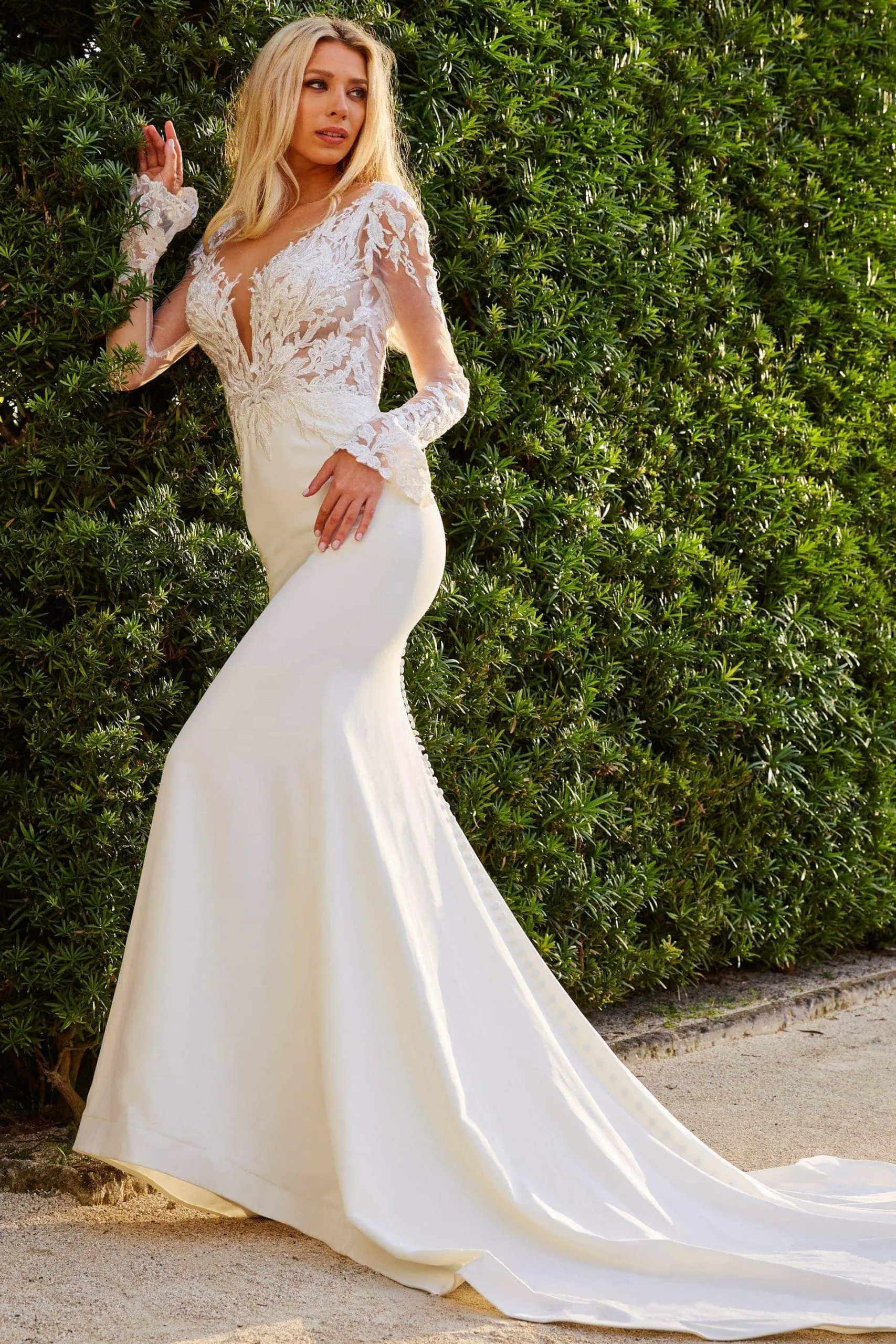 Model wearing Jovani JB07632 elegant ivory mermaid gown with lace sleeves and deep V-neckline.