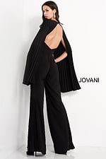 Model wearing Jovani 00756 black jumpsuit with pleated cape sleeves, back view.