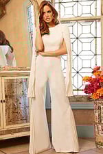 Model wearing Jovani 00756 ivory jumpsuit with pleated cape sleeves, front view with long sleeves shown.