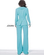 Model wearing Jovani 02637 turquoise ensemble with deep V-neck and jeweled buttons, back view.