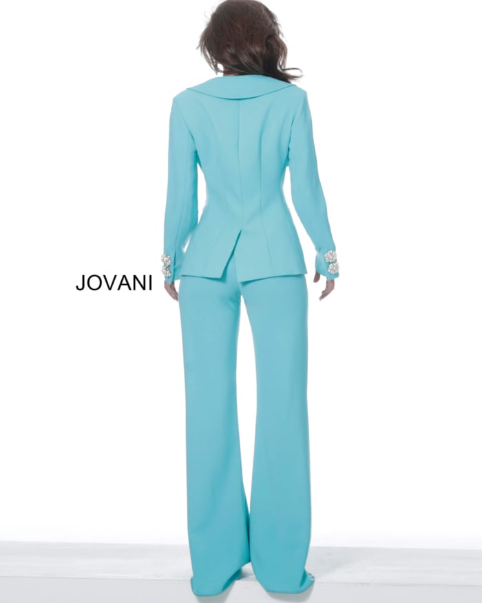 Model wearing Jovani 02637 turquoise ensemble with deep V-neck and jeweled buttons, back view.
