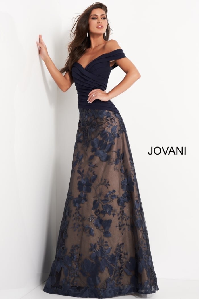 Model in Jovani 02852 navy gown with A-line silhouette and floral embroidery design.