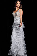 Model in Jovani 03023 gray gown with decorative embellishments and feathers, angled front view.