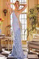 Model wearing Jovani 03389 blue gown with floral embellishments and feathers, hands on head.