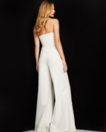 Model wearing Jovani 03828 ivory strapless jumpsuit back view showing off wide-leg pants.