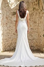 Back view of a fitted satin gown with draped cowl back, button detailing, and flowing train.