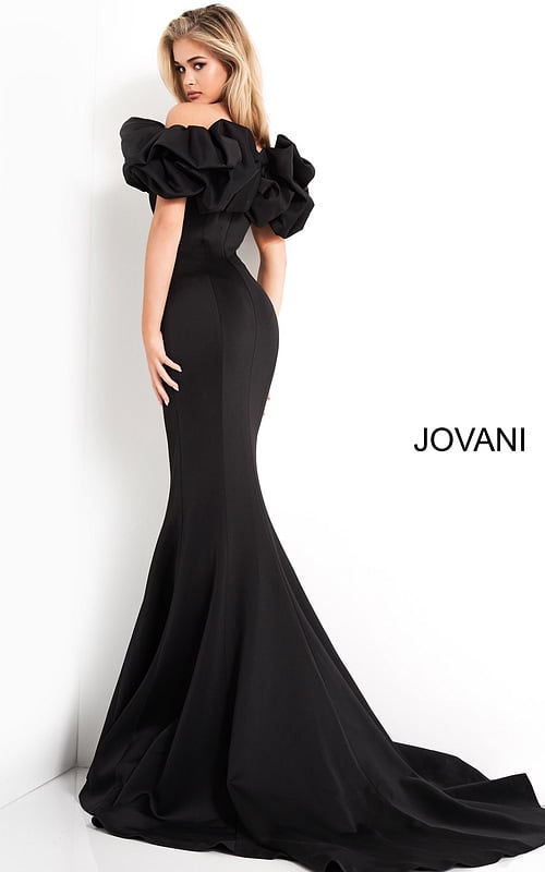 Model wearing Jovani 04368 black mermaid gown with ruffled sleeves, back view.
