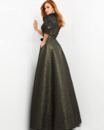 Model elegantly posing in a Jovani 05075 green dress with three-quarter sleeves.
