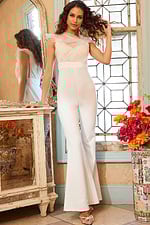Model wearing Jovani 05676 ivory jumpsuit with lace bodice and flared legs.