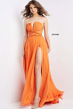 Model showing back view of Jovani 05971 orange dress with flowing fabric and criss-cross detail.