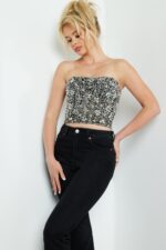 Model wearing Jovani 06854 black crop top with floral silver accents, front view.