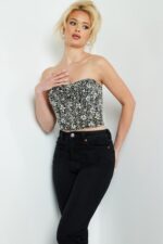 Model wearing Jovani 06854 black crop top with silver embellishments, front view.