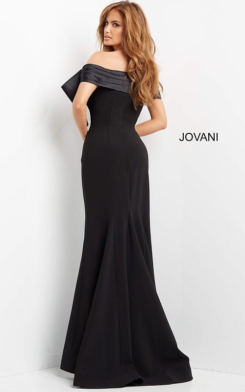 Model wearing Jovani 07014 black off-the-shoulder gown with large bow, back view.