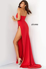 Model wearing Jovani 07138 red dress with sweetheart neckline and high slit from the back view.
