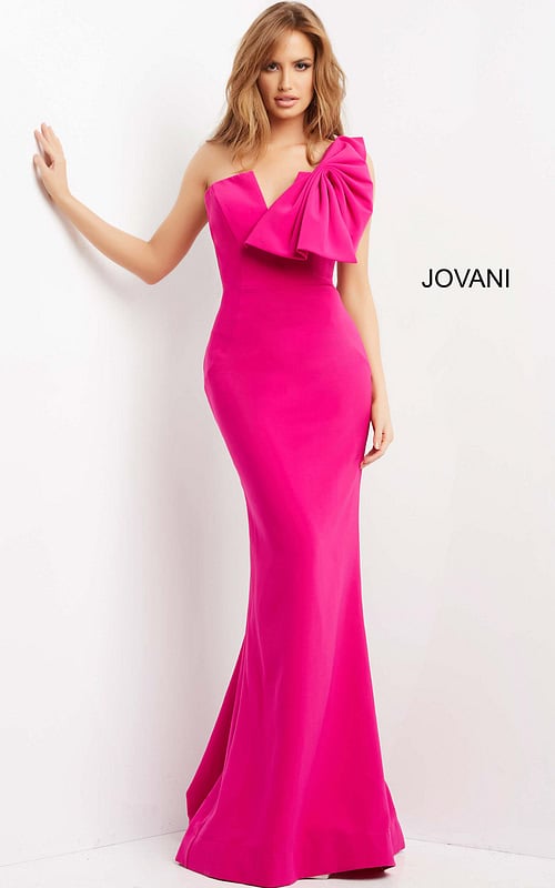 Model wearing Jovani 07306, fuchsia dress with asymmetric neckline and bow, front view.