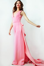 Model in Jovani 08000 pink jumpsuit with a dramatic floor-length feature from the side view.