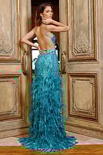 Model showcasing the back view of Jovani 08340 turquoise gown with open back and feathers.
