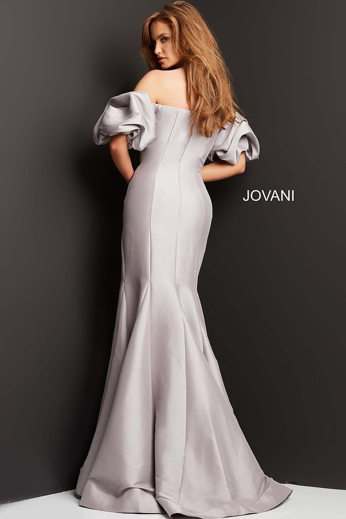 Back view of model in Jovani 08361 taupe mermaid gown with off-shoulder puff sleeves.