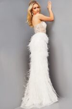 Model wearing Jovani 08525 back view highlighting the sheer back and continuation of the feathered skirt.