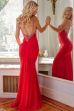 Model wearing Jovani 09009 red dress with low-cut back