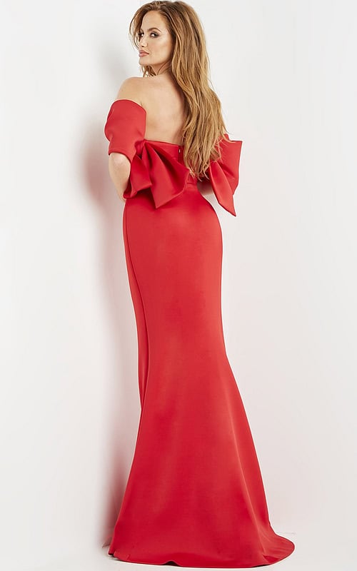 Model wearing Jovani 09064 red dress showing the back and large bow detail.