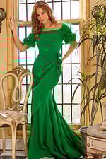 Model in Jovani 09154 green dress, front view, feathered sleeves in natural light.