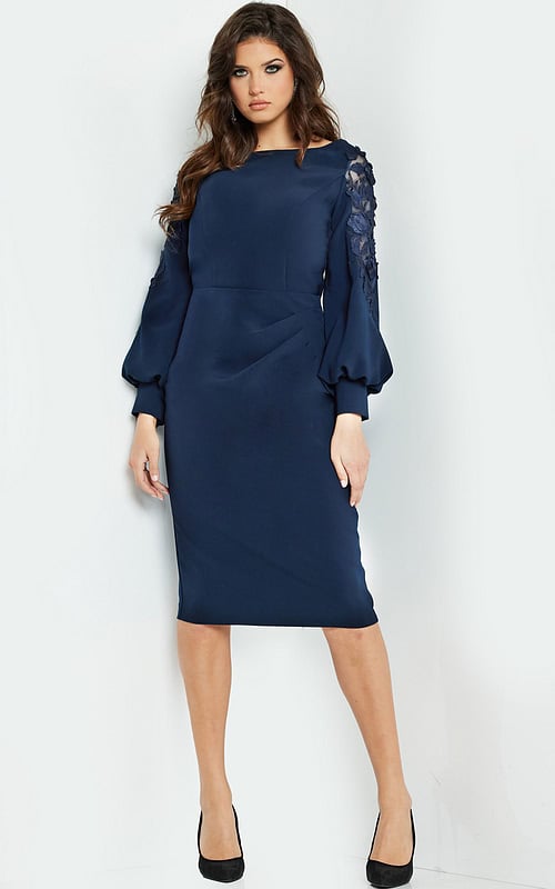 Model wearing Jovani 09471, a knee-length navy dress with balloon sleeves and boat neckline, front view