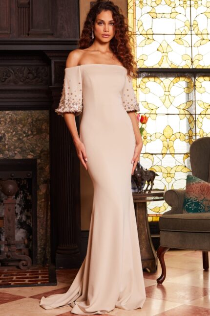 Model wearing elegant Jovani 09516 beige gown with off-the-shoulder neckline and floral sleeve embellishments, front view.