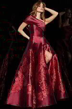 Model in Jovani 09610 red dress with asymmetric neckline and high slit.