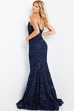 Model wearing Jovani 09768 in navy back view, displaying intricate lace details.