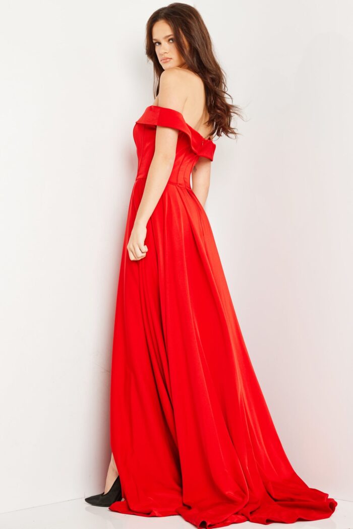 Back view of model in Jovani 09874 red gown showing off-the-shoulder design and full skirt.