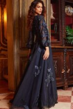 Model showcasing Jovani 09943 navy gown with sheer detailed sleeves from the back.