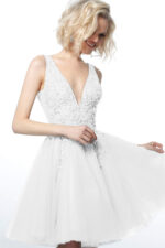 Model wearing Jovani 1774 white dress featuring a deep V-neckline and sparkling embellishments.