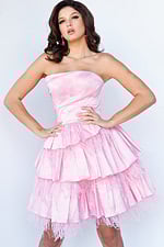 Model wearing Jovani 22326 pink strapless dress with ruffled tiers and feather details