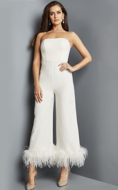 Model wearing Jovani 22590 ivory strapless jumpsuit with feathered hem from the front.