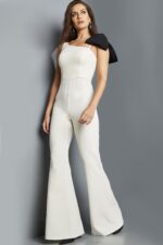 Model wearing Jovani 22589 ivory jumpsuit with asymmetrical neckline, full view.