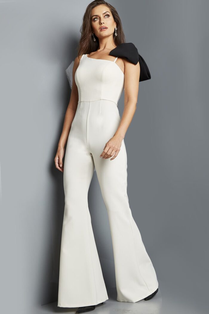 Model wearing Jovani 22589 ivory jumpsuit with asymmetrical neckline, full view.